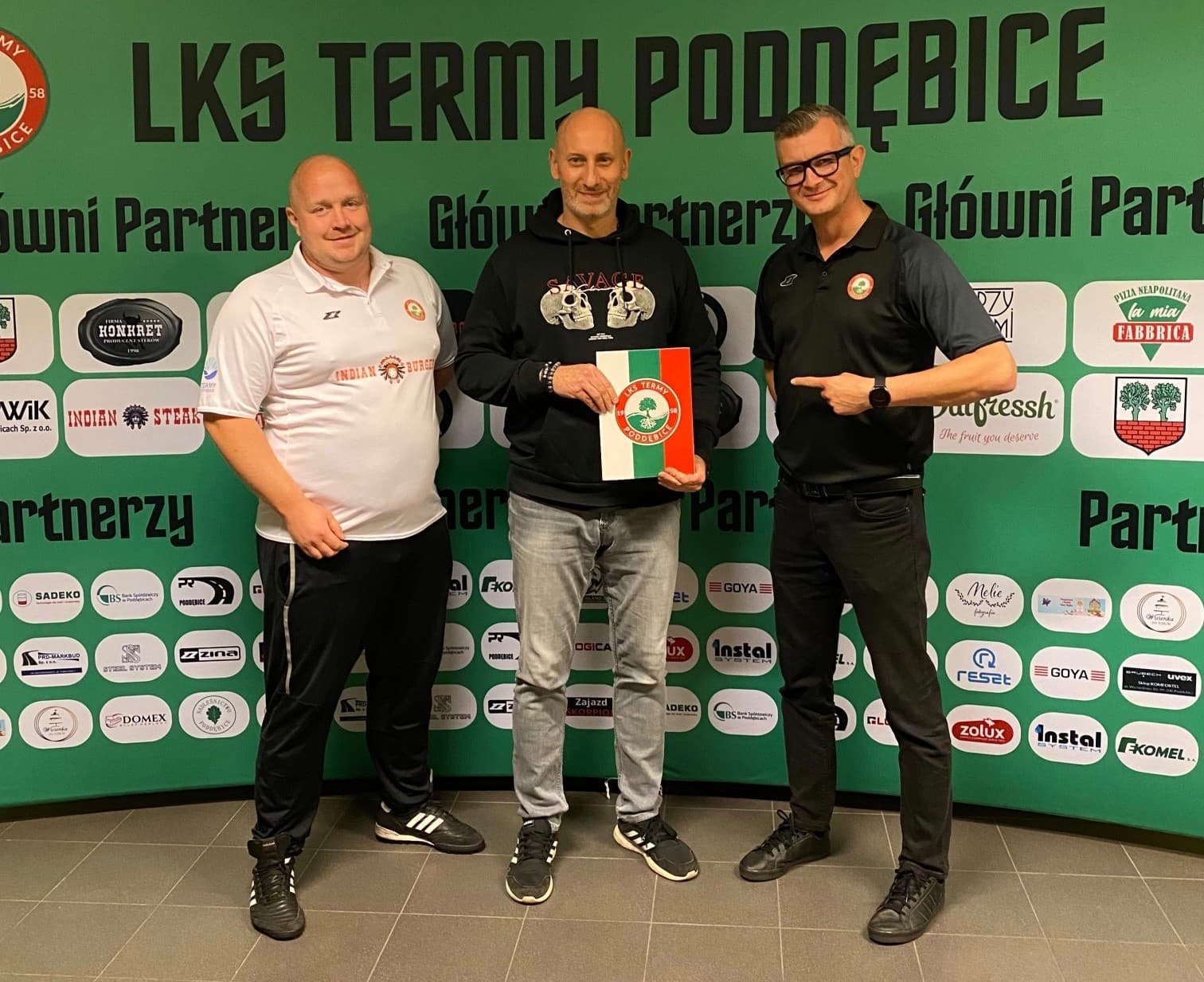 Przedstawiciele LKS Termy Poddębice i trener mentalny Grzegorz Zareda przed ścianką sponsorów klubu