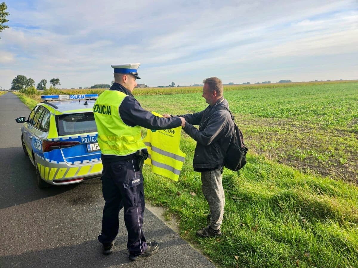 Policjantka przekazuje kamizelkę odblaskową mieszkance