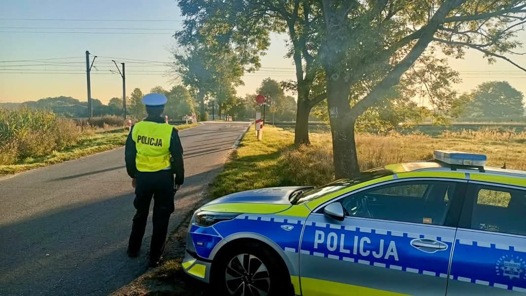 Policjant przy przejeździe kolejowym podczas akcji Bezpieczny przejazd kolejowy